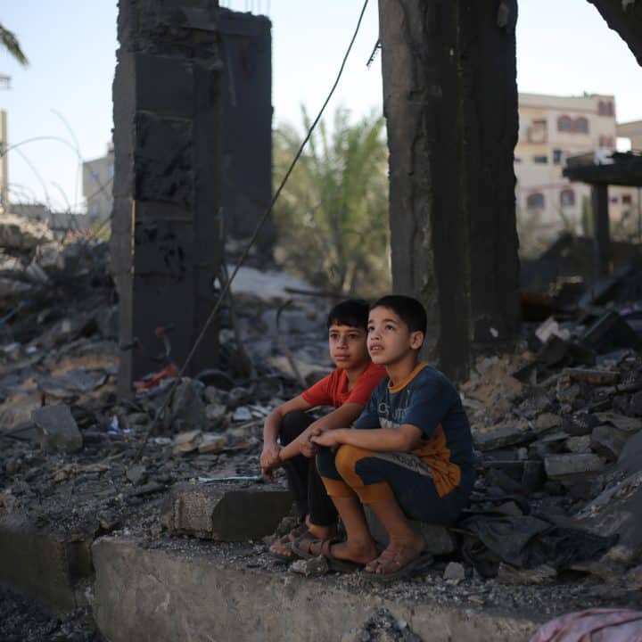 Deux enfants palestiniens sont assis dans les décombres de ce qui reste de leur maison dans la ville de Rafah, au sud de la bande de Gaza. ©UNICEF/UNI485696/El Baba
