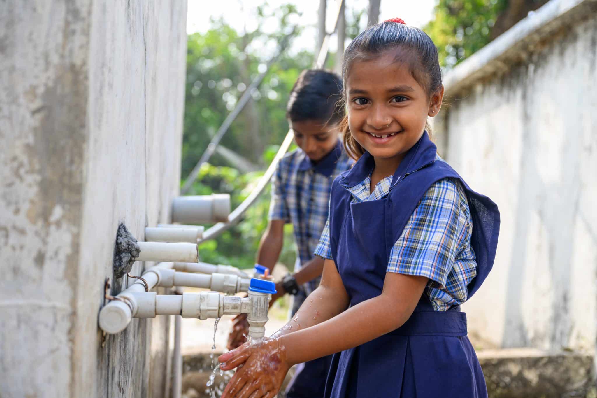 Des enfants se lavent les mains grâce à des installations d'eau soutenues par l'UNICEF en Inde. © UNICEF/UNI490120/Panjwani