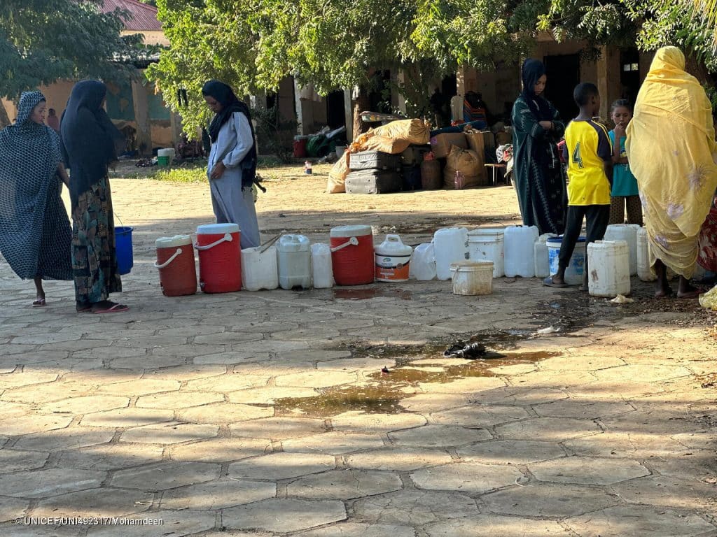 Des familles font la queue pour remplir leurs seaux d'eau, dans le camp un camp de déplacés à Sennar, au Soudan. © UNICEF/UNI492317/Mohamdeen