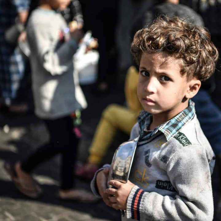 Ahmad, 5 ans, attend son tour dans la foule pour recevoir un repas d'un centre caritatif qui distribue de la nourriture gratuitement dans la ville de Rafah, au sud de la bande de Gaza. © UNICEF/UNI495575/ZAGOUT