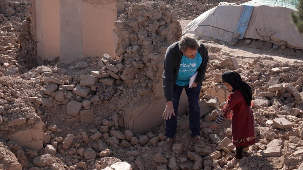 Le 14 janvier 2024, Daniel Timme, chef de la communication de l'UNICEF Afghanistan, s'entretient avec Adina, 8 ans, et sa mère Mahbuba au milieu des décombres de leur ancienne maison, détruite par les tremblements de terre d'octobre dernier dans le village de Karnil, district de Zinda Jan, en Afghanistan. © UNICEF/UNI502647/Karimi