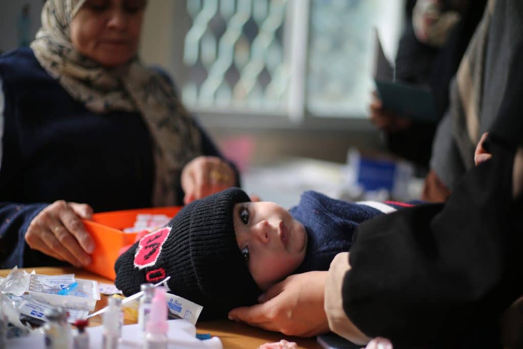 Le 3 janvier 2024, un petit enfant se fait vacciner dans un dispensaire à Rafah. © UNICEF/UNI504012/ alBaba