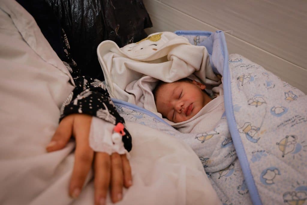 Le 12 janvier 2024, dans l'État de Palestine, une femme est allongée à côté de son nouveau-né dans la maternité émiratie de Rafah, dans le sud de la bande de Gaza. ©UNICEF/UNI504905/AlBaba