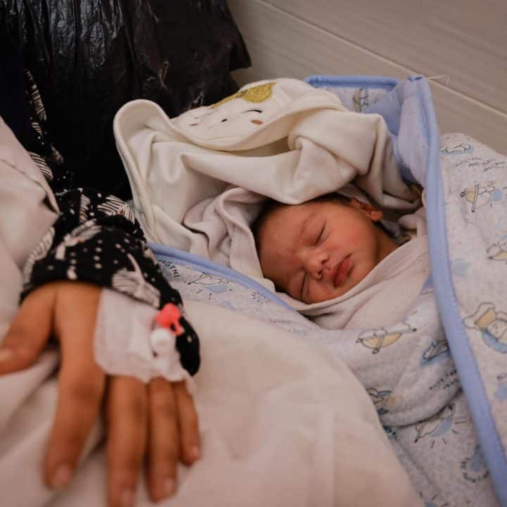 Le 12 janvier 2024, dans l'État de Palestine, une femme est allongée à côté de son nouveau-né dans la maternité émiratie de Rafah, dans le sud de la bande de Gaza. ©UNICEF/UNI504905/AlBaba