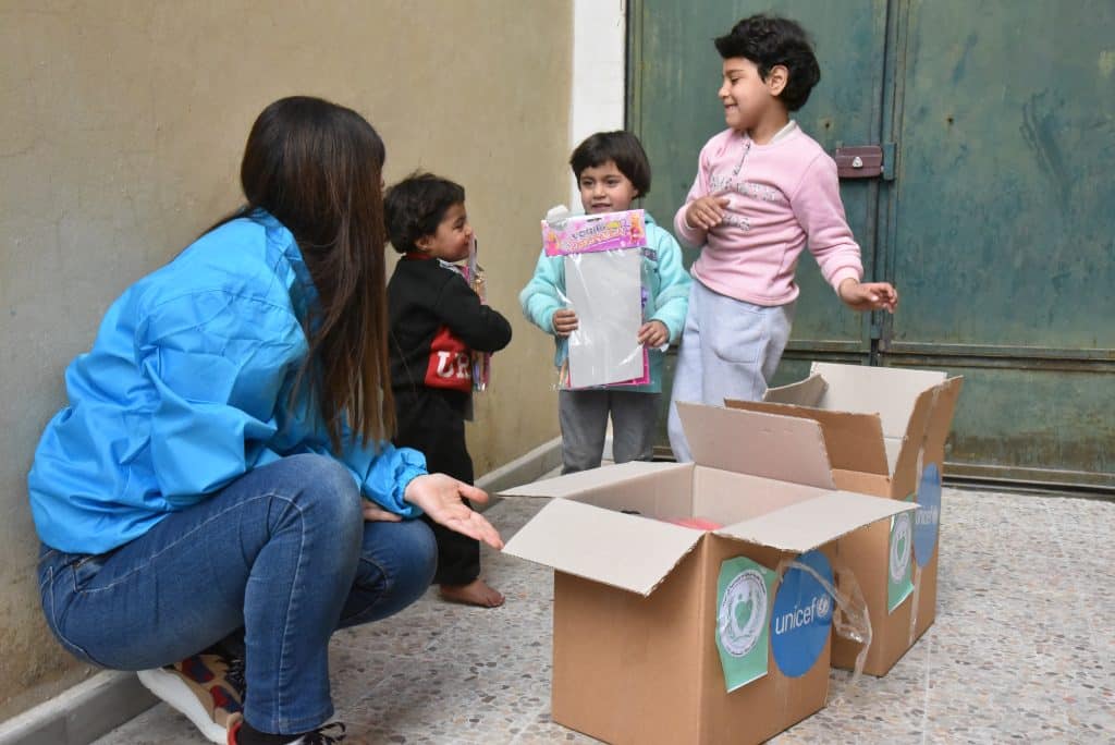 Le 7 mars 2023, Jana, 3 ans, Retaj, 5 ans, et Maya, 8 ans, découvrent leurs nouveaux vêtements chauds et des jouets fournis par l'UNICEF et ses partenaires, pour soutenir les enfants affectés par les tremblements de terre dans la ville de Hama, en Syrie. © UNICEF/UN0804557/Hazori