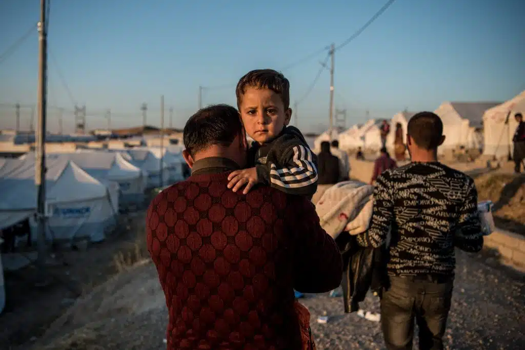 Le 6 novembre 2019, Abdullah porte son fils de deux ans et demi, Ahmed, jusqu'à leur tente après avoir fui les combats en Syrie et être arrivé au camp de Bardarash, près de la ville de Dohuk, dans le nord de l'Irak. © UNICEF/UNI225359/Yar