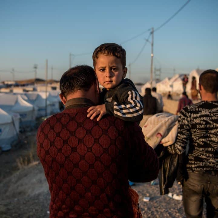 Le 6 novembre 2019, Abdullah porte son fils de deux ans et demi, Ahmed, jusqu'à leur tente après avoir fui les combats en République arabe syrienne et être arrivé au camp de Bardarash, près de la ville de Dohuk, dans le nord de l'Irak. © UNICEF/UNI225359/Yar