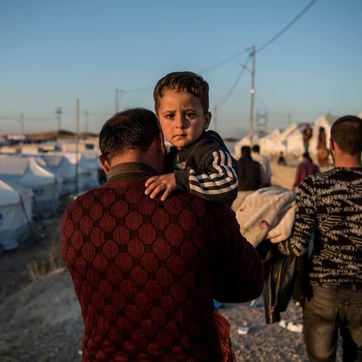 Le 6 novembre 2019, Abdullah porte son fils de deux ans et demi, Ahmed, jusqu'à leur tente après avoir fui les combats en Syrie et être arrivé au camp de Bardarash, près de la ville de Dohuk, dans le nord de l'Irak. © UNICEF/UNI225359/Yar