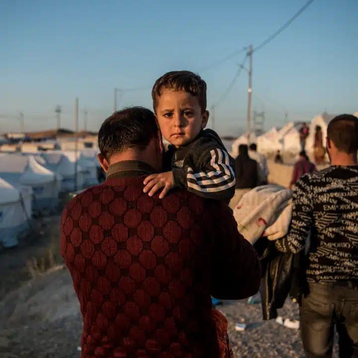 Le 6 novembre 2019, Abdullah porte son fils de deux ans et demi, Ahmed, jusqu'à leur tente après avoir fui les combats en Syrie et être arrivé au camp de Bardarash, près de la ville de Dohuk, dans le nord de l'Irak. © UNICEF/UNI225359/Yar