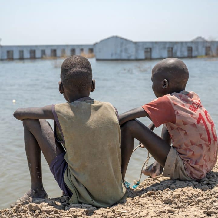 Le 4 mars 2023, des garçons regardent leur école inondée à Bentiu, dans l'État de l'Unité, au Sud-Soudan. D'importantes inondations ont touché des milliers de personnes dans l'État de l'Unité et beaucoup ont dû fuir leur maison.© UNICEF/UNI424890/Naftalin