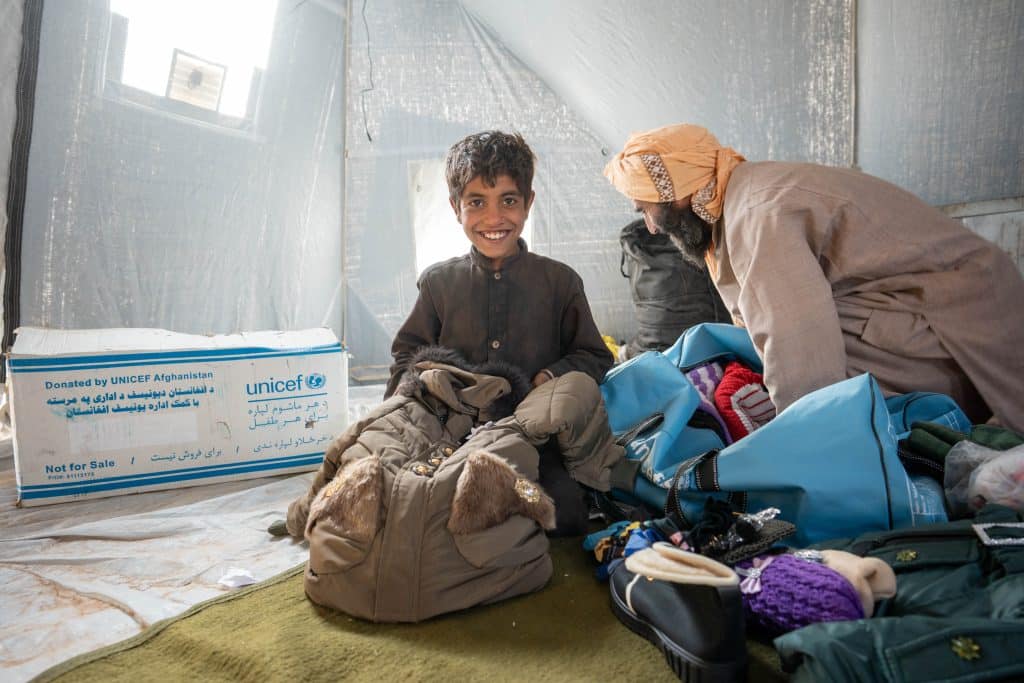 Le 12 octobre 2023, Sefafullah, 10 ans, et son oncle déballent leur kit hiver, fourni par l'UNICEF aux familles qui ont perdu leurs maisons et leurs biens lors des tremblements de terre dans l'ouest de l'Afghanistan. © UNICEF/UNI452560/Naftalin