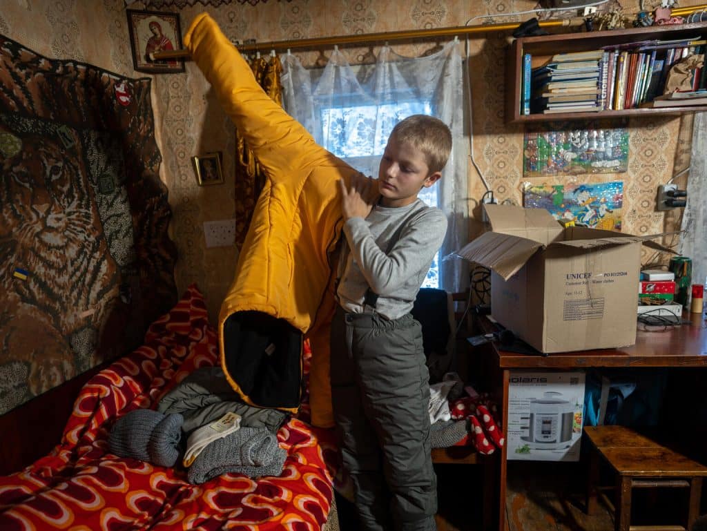 Bohdan, 11 ans, vit à Izyum, dans la région ukrainienne de Kharkivska, une ville qui a été presque totalement détruite en deux ans de conflit. Sa famille et lui font partie des nombreux foyers qui ont reçu des kits hiver de l'UNICEF © UNICEF/UNI496714/Filippov
