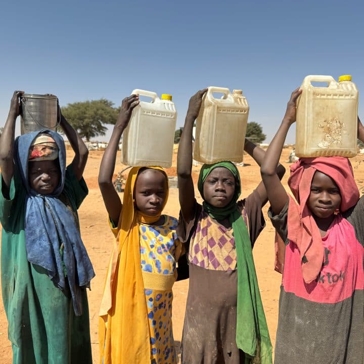 Le 3 février 2024, des enfants transportent des récipients d'eau après les avoir remplis dans un puits foré par l'UNICEF à l'intérieur du camp de réfugiés d'Adré, au Tchad. ©UNICEF/UNI514949/Le Du