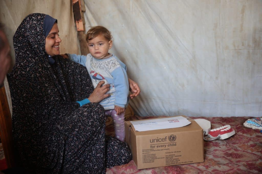 Le 28 janvier 2025, les familles du camp de Maka à Deir al Balah, au centre de la bande de Gaza, reçoivent des vêtements d'hiver pour les aider à rester au chaud pendant les mois froids de l'hiver dans l'État de Palestine. © UNICEF/UNI728634/El Baba