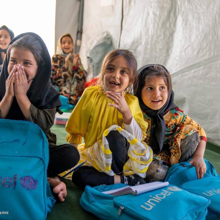 Le 3 décembre 2023, des élèves sourient lors d'une visite de Naysán Sahba, Directrice de la Division de la communication mondiale et du plaidoyer de l'UNICEF, dans un établissement scolaire soutenu par l'UNICEF dans le district de Zinda Jan, touché par le tremblement de terre, dans la province d'Herat, en Afghanistan, le 03/12/2023. © UNICEF/UNI485375/Karimi