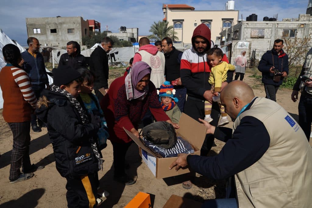 Avec le soutien de l'Aide humanitaire de l'Union européenne (ECHO), des membres du personnel de l'UNICEF distribuent des vêtements chauds à des familles déplacées à Rafah, dans le sud de la bande de Gaza. © UNICEF/UNI514365/El Baba
