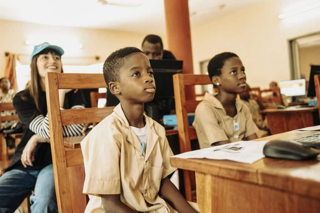 Visite de CLARA LUCIANI, ambassadrice UNICEF, au BENIN. Visite de la salle informatique du CEG 2 BOHICON rénovée, où les élèves apprenent à se servir d'un ordinateur et d'internet, notamment via la plateforme YOMA. Avec Jean-Claude (10 ans) et Marlonne (12 ans). © UNICEF/Decoin