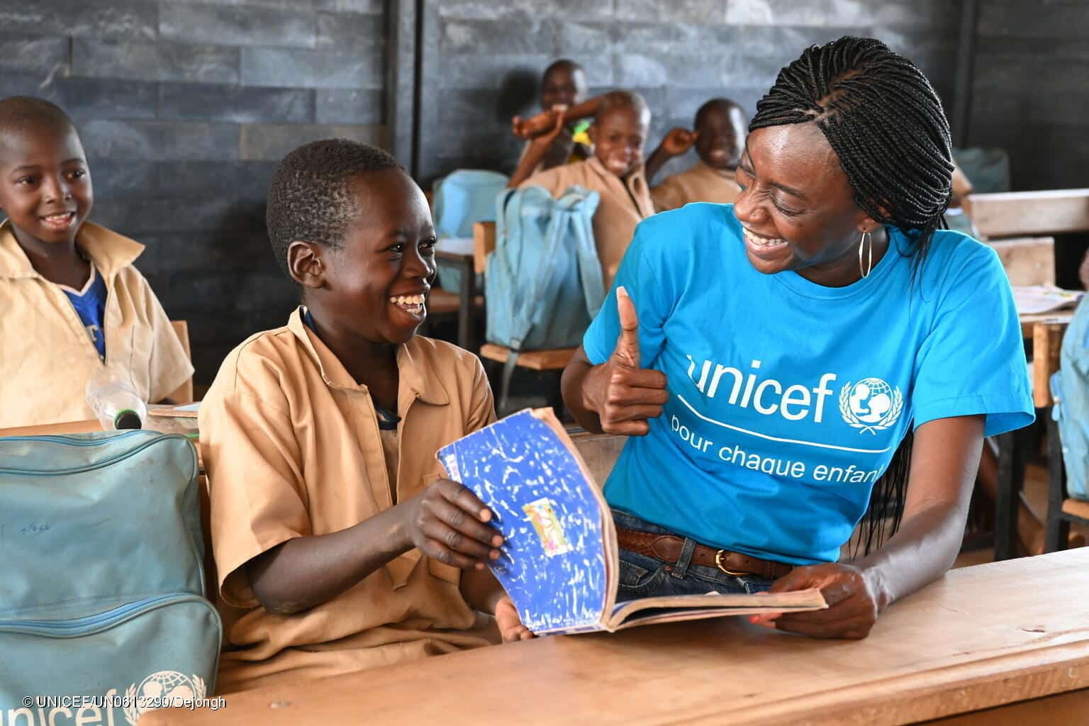 Fanta, membre du personnel de l'UNICEF, avec des élèves en classe dans une école fabriquée à partir de briques en plastique recyclées, à Nabekounoubobo, un village du nord de la Côte d'Ivoire. © UNICEF/UN0613290/Dejongh