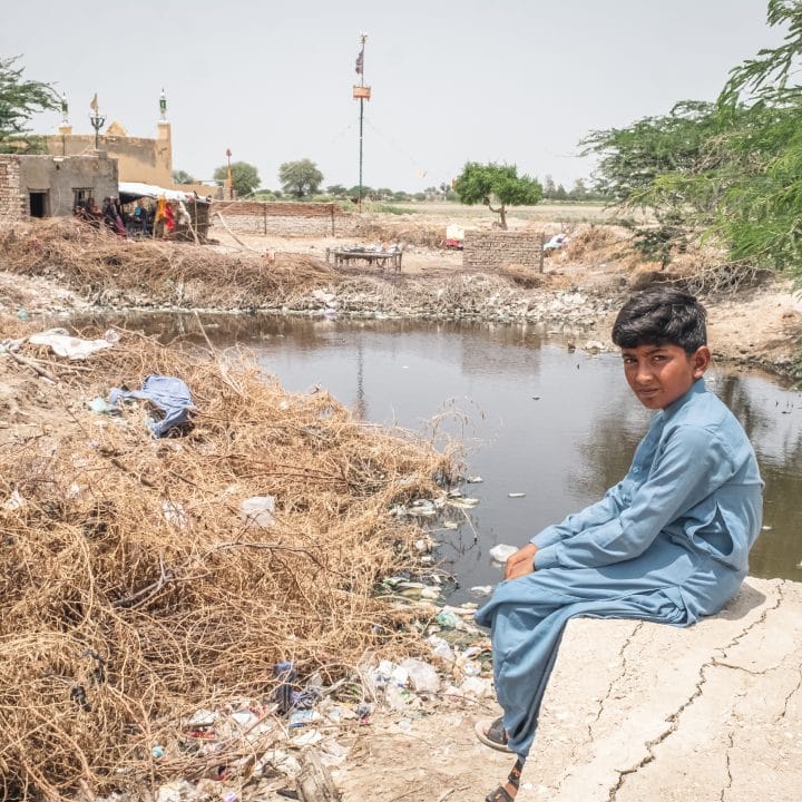 Ishaq Bibi, 11 ans, est assis près de la zone inondée de son village de Geokaloi, dans la province de Sindh, au sud du Pakistan. ©UNICEF/UNI431609/Sokhin