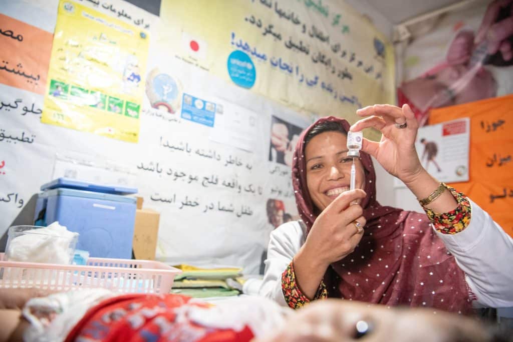 Le 22 octobre 2023, Sakina, vaccine un garçon de 11 mois à l'hôpital provincial Daikundi, soutenu par l'UNICEF, en Afghanistan. © UNICEF/UNI505663/Musadiq