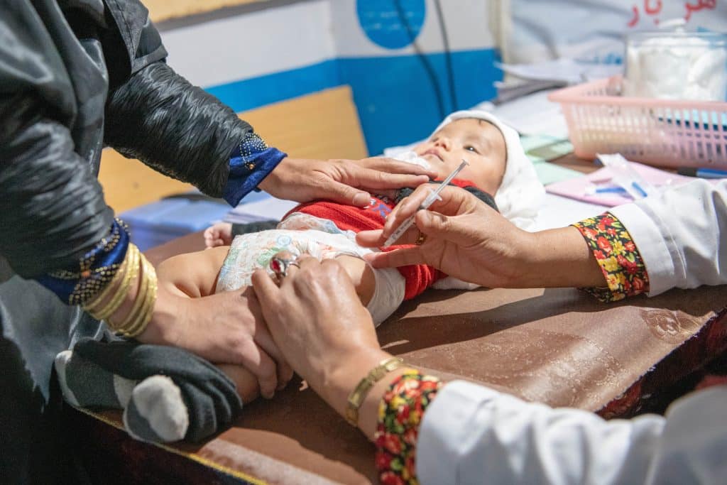 Le 22 octobre 2023, Sakina, vaccine un garçon de 11 mois à l'hôpital provincial Daikundi, soutenu par l'UNICEF, en Afghanistan. © UNICEF/UNI505665/Musadiq