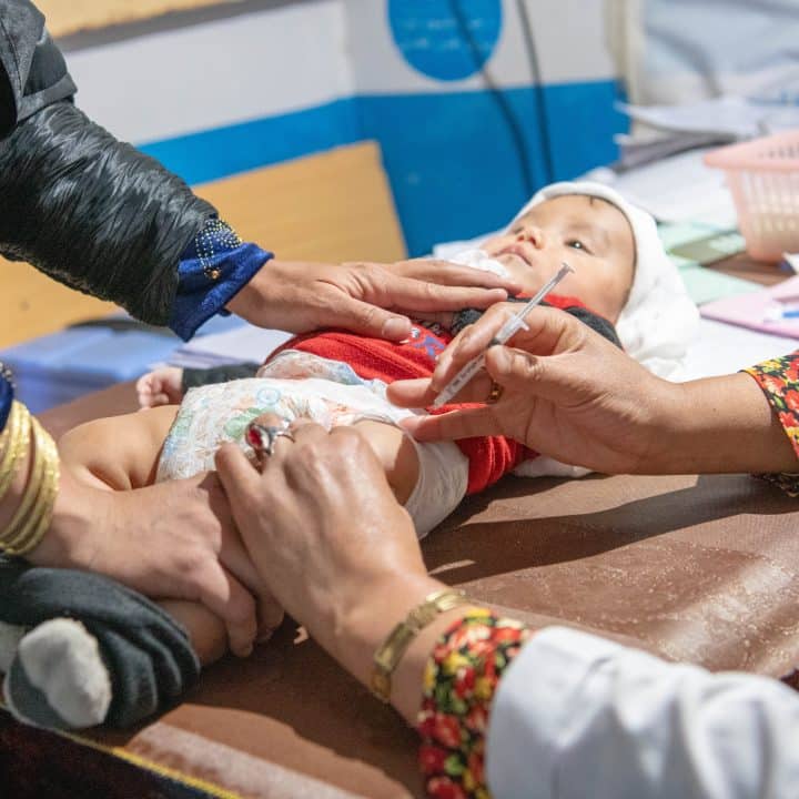 Le 22 octobre 2023, Sakina, vaccine un garçon de 11 mois à l'hôpital provincial Daikundi, soutenu par l'UNICEF, en Afghanistan. © UNICEF/UNI505665/Musadiq