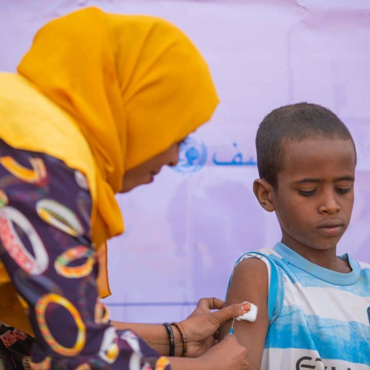 Wijdan Mahmoud a vaccinator and volunteer displaced from Gezira state and other members of the mobile team also dubbed ‘Al-Nazheen for the Displaced’ – locally translated ‘displaced for displaced’ - vaccinates children at the Al adad gathering shelter for displaced families in Kassala state. © UNICEF/UNI514467/Mohamdeen