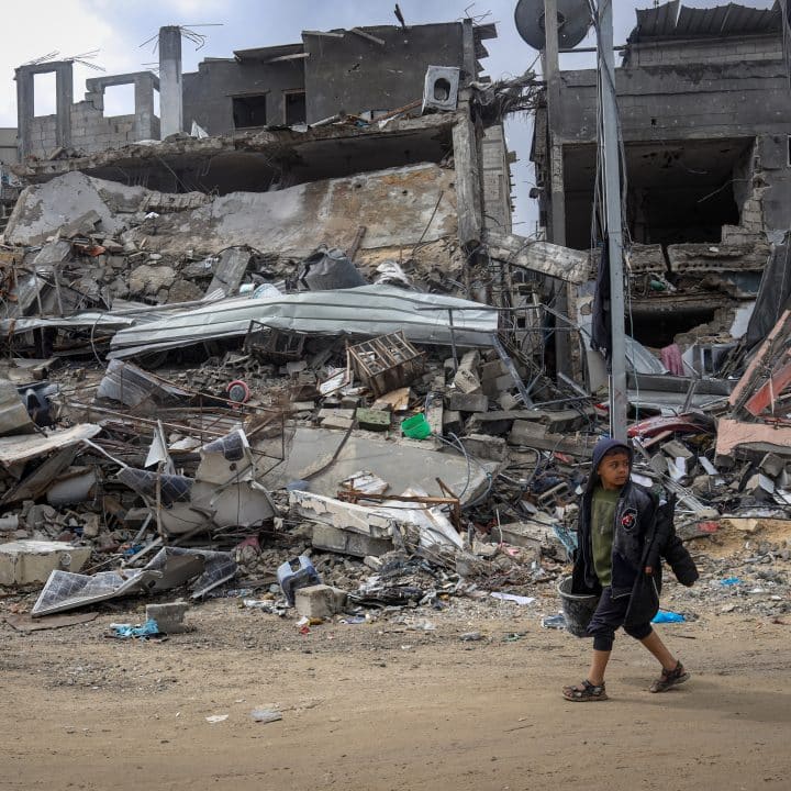 Tamer, 9 ans, passe devant les décombres de son quartier à Khan Younis, dans le sud de la bande de Gaza. © UNICEF/UNI544682/El Baba