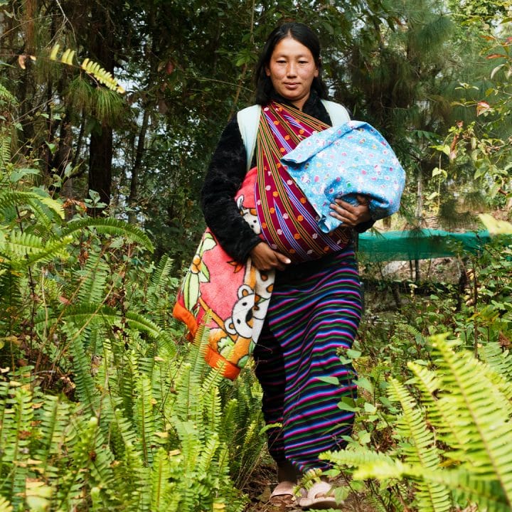 Sangay, 29 ans, marche à travers les bois jusqu'à la clinique de proximité pour faire vacciner son fils nouveau-né. Elle doit marcher pendant une heure pour atteindre la clinique. © UNICEF/UNI560264