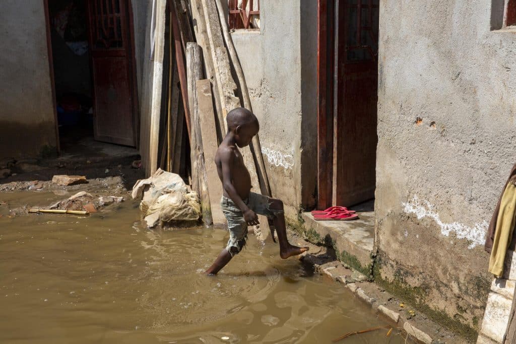 Le 7 mai 2022, un garçon marche dans les eaux de crue devant sa maison à Gatumba, au Burundi. En raison du changement climatique, la région est régulièrement inondée.© UNICEF/UN0770368/Prinsloo