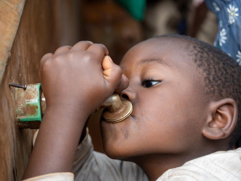 Au Burundi, un garçon boit de l'eau potable dans l'école de Busangana construite par l'UNICEF avec des matériaux écologiques.© UNICEF/UNI486160/Freese