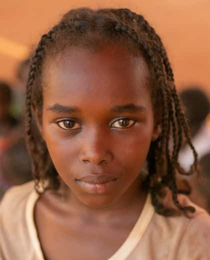 Le 15 août 2023, un enfant pose pour une photo lors d'une session de promotion de l'hygiène menée dans un point de rassemblement pour les personnes déplacées à Wad Madani, au Soudan.© UNICEF/UNI425218/Elfatih