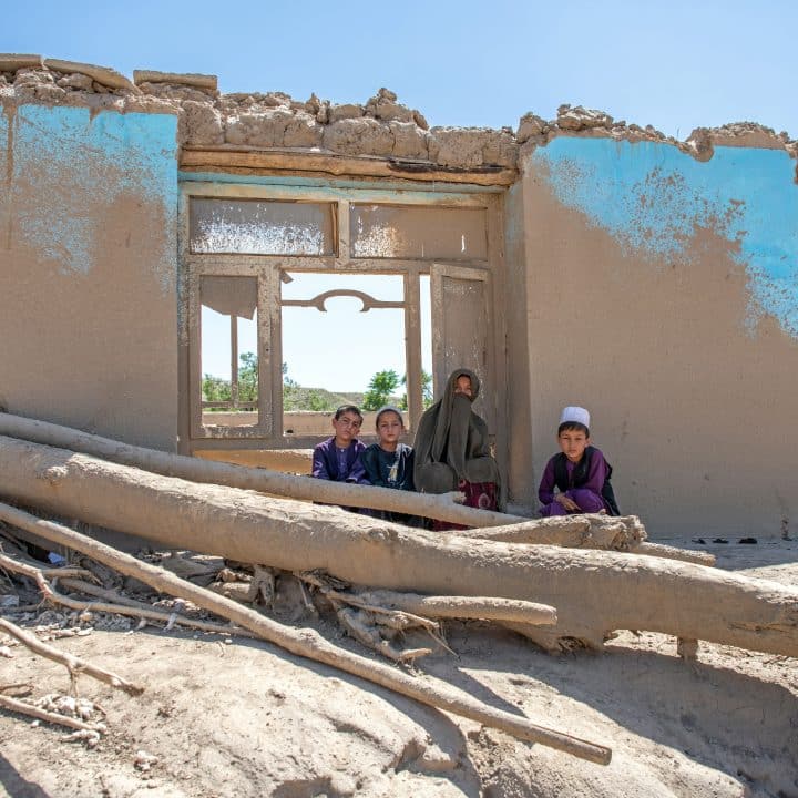Le 3 juin 2024, Bibi Nar, est assise avec ses enfants à l'extérieur de leur maison détruite à la suite des crues qui ont touché la province de Baghlan, dans le nord de l'Afghanistan. © UNICEF/UNI586033/Musadiq