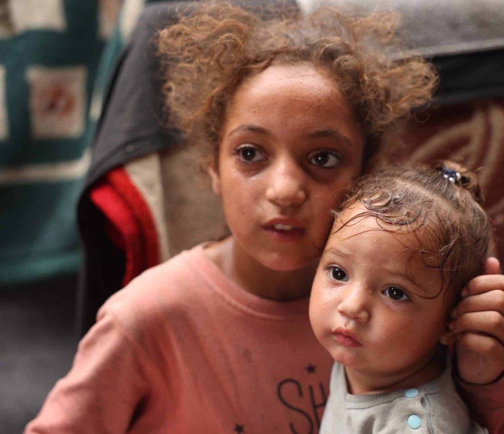 Rama, 11 ans, et sa sœur Malak, 1 an, sont réfugiées dans une tente à Deir al-Balah, dans la bande de Gaza.© UNICEF/UNI589857/El Baba