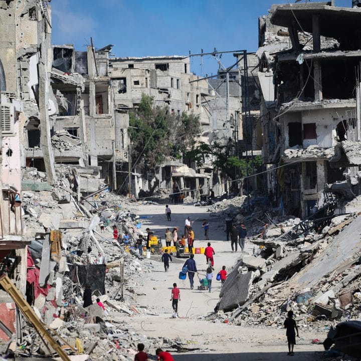 Au milieu des décombres, des enfants collectent de l'eau à Khan Younis, dans le sud de la bande de Gaza. La plupart des systèmes d'approvisionnement en eau de la bande de Gaza sont endommagés ou hors service en raison du manque de carburant ou des dommages subis © UNICEF/UNI580051/El Baba