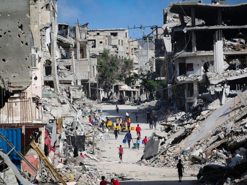 Au milieu des décombres, des enfants collectent de l'eau à Khan Younis, dans le sud de la bande de Gaza. La plupart des systèmes d'approvisionnement en eau de la bande de Gaza sont endommagés ou hors service en raison du manque de carburant ou des dommages subis © UNICEF/UNI580051/El Baba