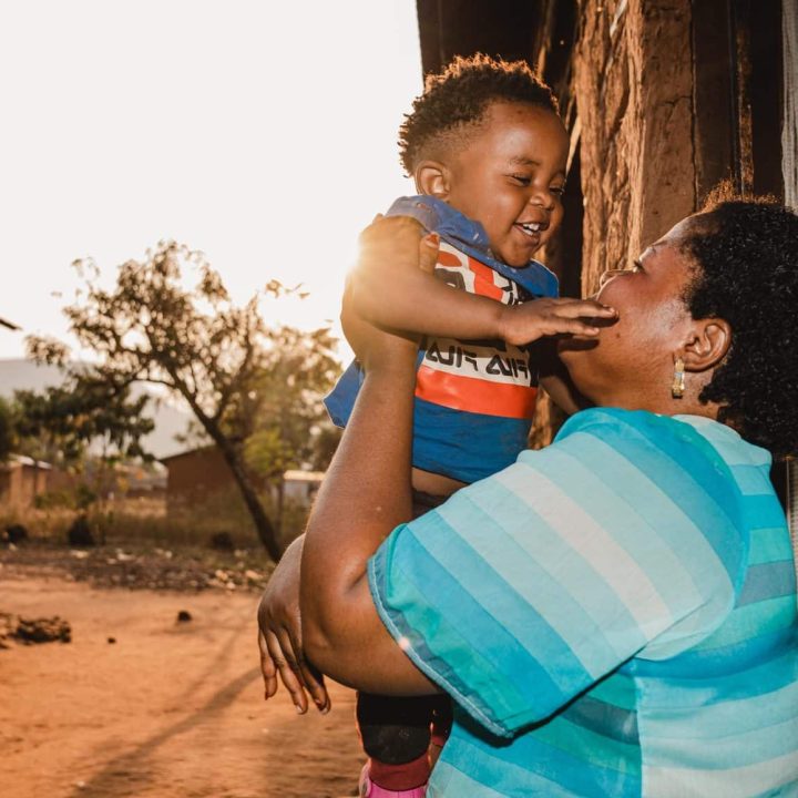 Gabriel, 1 an, joue avec sa mère Sarah à l'extérieur de leur maison à Kamanyola, dans la province du Sud-Kivu, en République démocratique du Congo. Le petit garçon a survécu à la mpox grâce à une prise en charge rapide à l'hôpital de Kamanyola, soutenu par l'UNICEF. © UNICEF/UNI624795/Benekire