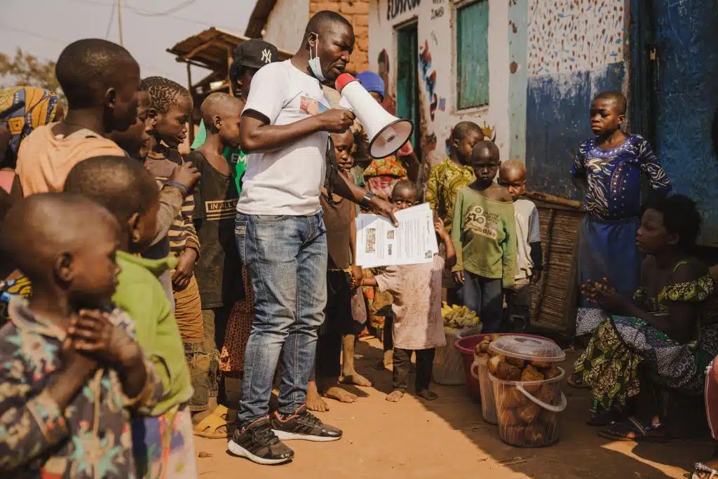 Innocent Murula, un agent de proximité soutenu par l'UNICEF, sensibilise sa communauté au sujet du Mpox à Kamanyola, dans la province du Sud-Kivu, en RDC, le 25 juillet 2024.© UNICEF/UNI624801/Benekire