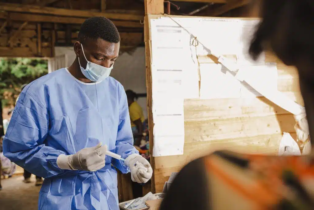 En RDC, à l'hôpital Kavumu soutenu par l'UNICEF, un infirmier prépare une injection pour le traitement d'un patient atteint de Mpox. © UNICEF/UNI624812/Benekire