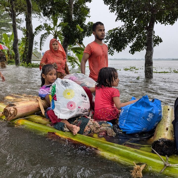 Des familles traversent les eaux de crue sur un radeau de fortune, à la recherche d'un abri, Feni, Bangladesh, août 2024. © UNICEF/UNI631578/