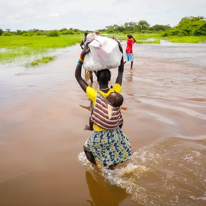 Les récentes inondations dans la région de Gambella, en Éthiopie, ont touché plus de 30 000 personnes, comme cette mère qui tente désespérément de traverser la rivière en crue en portant son bébé sur le dos, le 09/09/2024. © UNICEF/UNI640940/Pouget