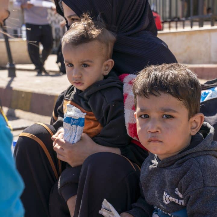 Le 5 octobre 2024, Ibrahim, 3 ans, et Ahmad, 1 an, sont assis avec leur mère à la frontière syrienne, après avoir fui l'escalade des violences au Liban. © UNICEF/UNI658536/Al-Asadi