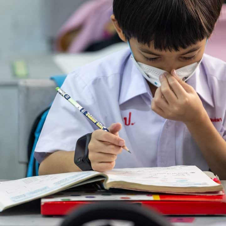 Des élèves de l'école Phor Panya, dans le district de Bang Kho Laem, à Bangkok, portent des masques PM 2,5 en classe alors que les niveaux de pollution de l'air dépassent la norme, ce qui nuit à leur santé. ©UNICEF/UNI715015/Janthong