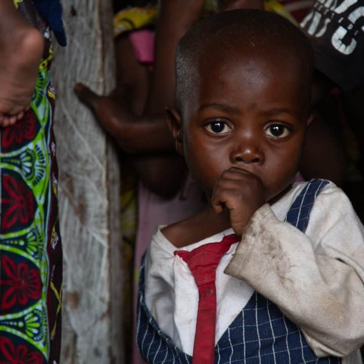 Des enfants font la queue pour obtenir du porridge lors d'un dépistage de la malnutrition dans un centre de nutrition soutenu par l'UNICEF sur le site de Bushagara pour les personnes déplacées, à la périphérie de Goma, en RDC. © UNICEF/UNI585416/Tremeau