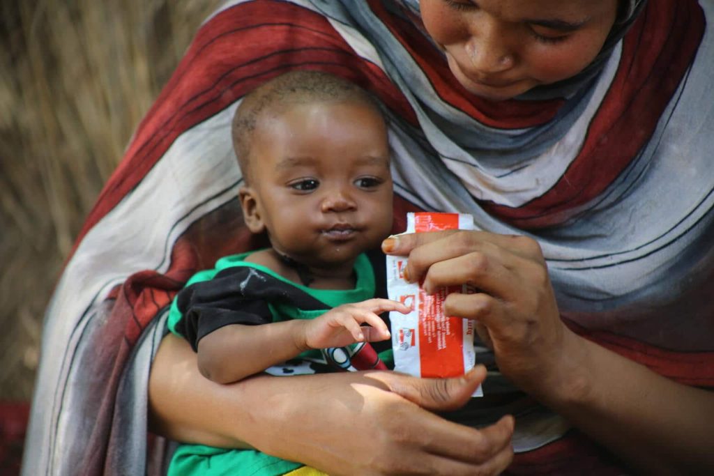 Manahil donne à son enfant de 6 mois, Baraa, des aliments thérapeutiques prêts à l'emploi (ATPE). État du Nil Bleu, Soudan, mai 2024. © UNICEF/UNI593643