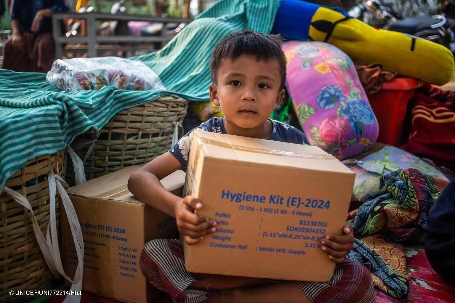 Le 31 mars 2025, un petit garçon de 5 ans porte une boîte de fournitures distribuées par l'UNICEF dans la région de Sagaing, à la suite du tremblement de terre de magnitude 7,7 qui a frappé le Myanmar le 28 mars. © UNICEF/UNI772214/Htet