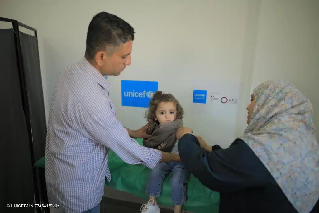 Photo prise le 03/04/2025 à Deir Al Balah, dans la bande de Gaza, illustrant une petite fille qui reçoit des soins de santé dans un centre de santé soutenu par l'UNICEF. © UNICEF/UNI774541/Skills