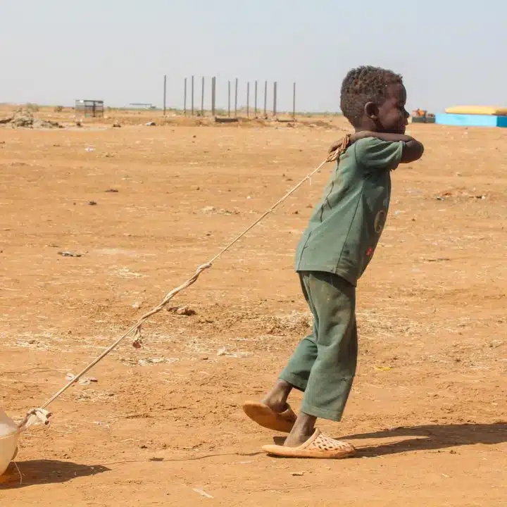 Asim, 3 ans, traîne un récipient après avoir puisé de l'eau potable dans l'un des points d'eau installés avec le soutien de l'UNICEF dans le camp de déplacés internes d'Almatar, dans l'État de Kassala, Soudan, janvier 2025. © UNICEF/UNI731432/Nakibuuka