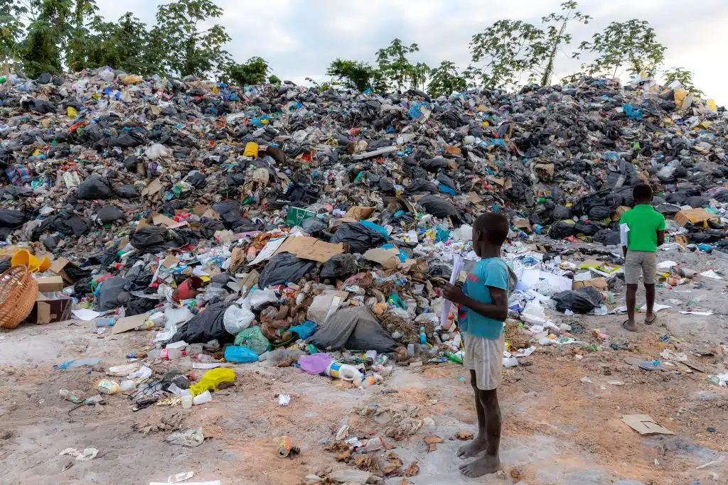 Photo prise d'un enfant en Guyane devant une montagne de déchêts en Guyane. © Jody Amiet / AFP