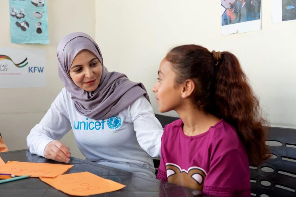 Le 31 août 2022, l'ambassadrice de bonne volonté de l'UNICEF, Muzoon Almellehan, est assise aux côtés de Raghad, 11 ans, lors d'un cours d'anglais dispensé dans un centre Makani soutenu par l'UNICEF à Amman Est, en Jordanie. © UNICEF/UN0696286/Matas